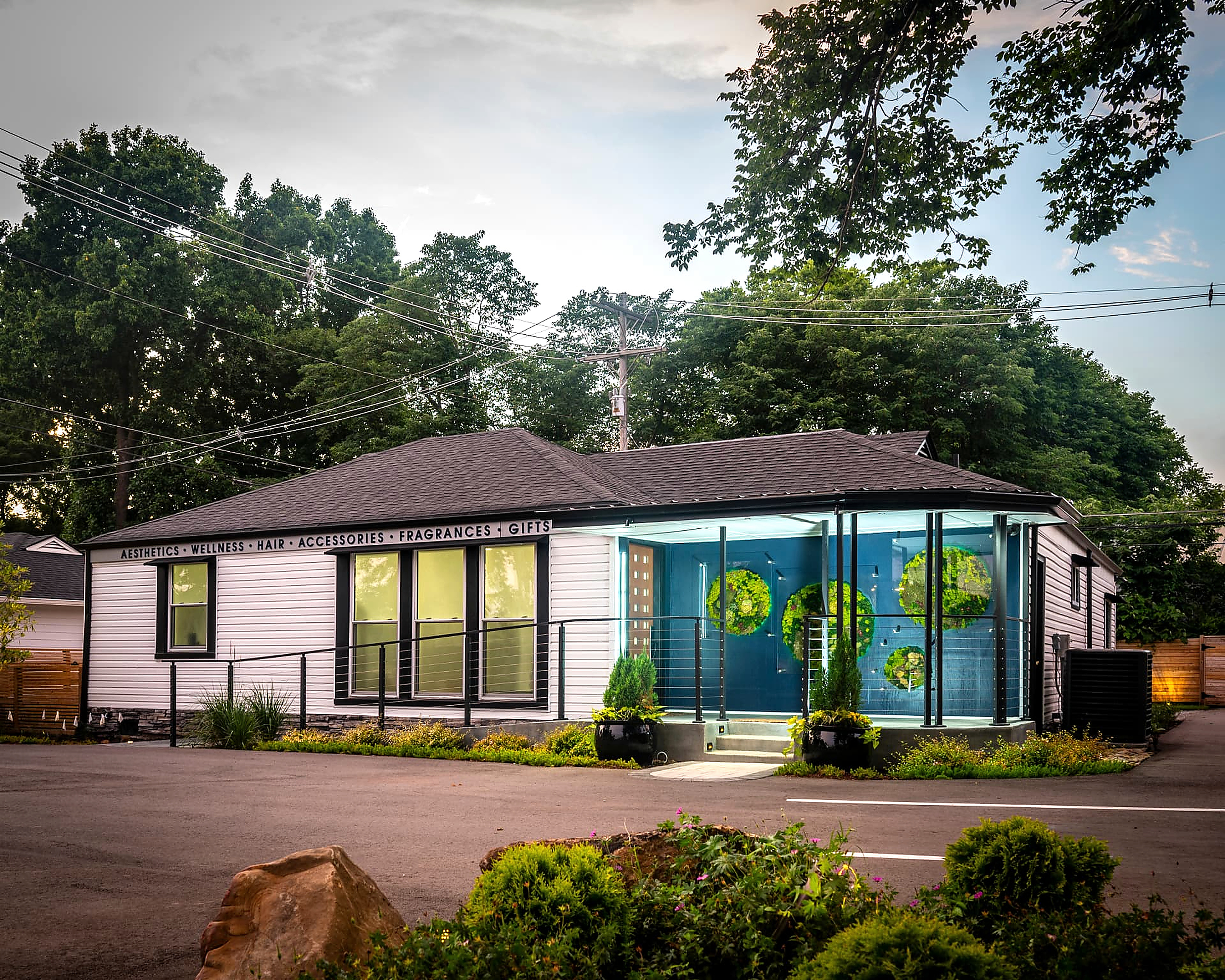 Twilight view of the fully renovated commercial building at 606 W Iris Drive, with lit glass-fronted entry and landscaped grounds